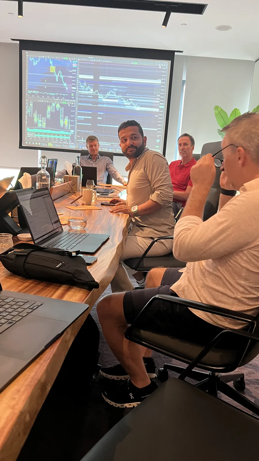 Session im Seminarraum beim TradeNeon Summit 2025 in Dubai: Laptops auf dem Tisch, vorne ein Chart auf der Leinwand